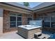 Hot tub on a gray stone patio with brick home exterior and large windows at 5268 Courtyard Ln, Belmont, NC 28012