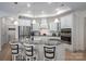 Modern kitchen with white cabinets, granite countertops, stainless steel appliances, and a center island with bar stools at 5268 Courtyard Ln, Belmont, NC 28012