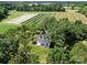 Aerial shot of a house nestled amidst trees, with farmland in the background at 550 Woodleaf Barber Rd, Cleveland, NC 27013