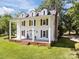Angle view of an elegant two-story home featuring white siding, black shutters, and a welcoming front porch at 550 Woodleaf Barber Rd, Cleveland, NC 27013