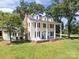 Charming two-story white home with a welcoming front porch, dark shutters, and a red brick chimney at 550 Woodleaf Barber Rd, Cleveland, NC 27013