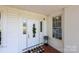 Elegant white front door with decorative glass, welcome mat, and adjacent window at 550 Woodleaf Barber Rd, Cleveland, NC 27013
