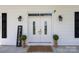 Elegant double front doors with glass panels, flanked by sconces and decorative plants, and a 'Welcome' sign at 550 Woodleaf Barber Rd, Cleveland, NC 27013