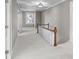 Bright upper hallway featuring neutral walls, new carpet, and a wooden staircase to the lower level at 550 Woodleaf Barber Rd, Cleveland, NC 27013
