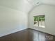 Bright bedroom with dark wood floors, large window, and vaulted ceilings, offering modern comfort at 631 May Green Dr, Clover, SC 29710