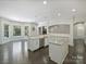 Open kitchen and dining area with granite counters, stainless appliances, dark floors, and stone fireplace beyond at 631 May Green Dr, Clover, SC 29710