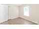Well-lit bedroom features wood-look flooring, a window with blinds, and closet at 6430 Matlea Ct, Charlotte, NC 28215