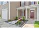 Inviting front porch with a decorative flowerbed, complemented by white stone and colorful plants at 6430 Matlea Ct, Charlotte, NC 28215
