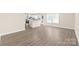 Open floor plan with wood-look flooring, flowing from the living area to the kitchen, offering seamless transition at 6430 Matlea Ct, Charlotte, NC 28215