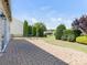 Beautifully landscaped backyard featuring a brick patio with lawn, plantings and mature trees at 7057 Shenandoah Dr, Fort Mill, SC 29707
