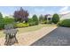 Nicely landscaped backyard with a brick patio, manicured lawn, shrubbery and mature shade trees at 7057 Shenandoah Dr, Fort Mill, SC 29707