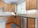 Kitchen featuring wood cabinets, stainless steel dishwasher, and granite countertops at 7057 Shenandoah Dr, Fort Mill, SC 29707