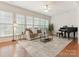 Bright living room with hardwood floors, piano, and an abundance of natural light from large windows at 7057 Shenandoah Dr, Fort Mill, SC 29707