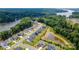 Aerial view of a neighborhood with modern homes, a pond, and lush green surroundings near a river at 7058 Cloer Ct, Charlotte, NC 28214