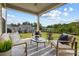 Covered patio overlooking a large backyard surrounded by mature trees and black metal fence at 7058 Cloer Ct, Charlotte, NC 28214