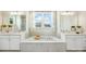 Luxurious bathroom featuring double vanities, a soaking tub, and bright lighting at 7058 Cloer Ct, Charlotte, NC 28214