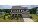 Charming two-story home with a manicured lawn, covered front porch, and attached two-car garage at 7058 Cloer Ct, Charlotte, NC 28214