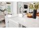 A kitchen island shows a white farmhouse sink, modern faucet, and quartz countertop perfect for food preparation and entertaining at 7058 Cloer Ct, Charlotte, NC 28214