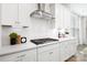 A clean and modern kitchen features white cabinetry, subway tile backsplash, and stainless steel range hood at 7058 Cloer Ct, Charlotte, NC 28214