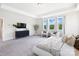 Large main bedroom with a tray ceiling, natural light, and a comfortable seating area at 7058 Cloer Ct, Charlotte, NC 28214