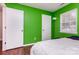 Green bedroom with wood floors, a window, and two white doors at 7224 Newell Acres Dr, Charlotte, NC 28215