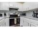 Well-lit kitchen featuring white cabinets, marble countertops, and modern appliances at 7224 Newell Acres Dr, Charlotte, NC 28215