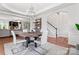Open concept dining area with hardwood floors, decorative chandelier, and seamless flow into the living room and stairway at 7355 Drury Ln, Denver, NC 28037