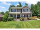Charming two-story home featuring a well-manicured lawn and a welcoming front porch, creating an inviting curb appeal at 7355 Drury Ln, Denver, NC 28037