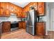 Modern kitchen featuring stainless steel appliances, warm wood cabinetry, and a functional layout for cooking convenience at 7355 Drury Ln, Denver, NC 28037