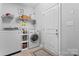 Functional laundry room with modern washer/dryer units and storage shelves at 7355 Drury Ln, Denver, NC 28037