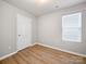 Bedroom with natural light, wood-look floors, and a door for convenient access at 8516 Paw Valley Ln, Charlotte, NC 28214