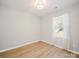 Bedroom featuring wood-look floors, neutral walls, and a window with coverings at 8516 Paw Valley Ln, Charlotte, NC 28214