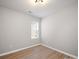 A bright bedroom featuring wood-look floors and a window for natural light at 8516 Paw Valley Ln, Charlotte, NC 28214