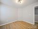 Bedroom featuring wood-look floors, light walls, and overhead lighting at 8516 Paw Valley Ln, Charlotte, NC 28214