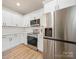 Modern kitchen with stainless steel appliances, white cabinetry, and hardwood floors at 8516 Paw Valley Ln, Charlotte, NC 28214