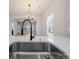 Stylish kitchen with quartz countertop, stainless sink, and view into living area at 8516 Paw Valley Ln, Charlotte, NC 28214