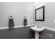 Stylish bathroom features a pedestal sink, framed mirror, and gray walls with classic wainscoting at 9410 Culcairn Rd, Huntersville, NC 28078