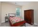 Cozy bedroom with a charming quilt, side table and a dark wood armoire at 9410 Culcairn Rd, Huntersville, NC 28078