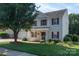 Charming two-story home features a well-manicured lawn, mature tree, and red shutters that add a pop of color at 9410 Culcairn Rd, Huntersville, NC 28078