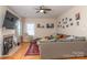 The living room has hardwood floors, a ceiling fan, a fireplace, and a comfortable gray sectional at 9410 Culcairn Rd, Huntersville, NC 28078