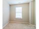Neutral bedroom features a single window and tan carpet at 9530 Drains Bay Ct, Charlotte, NC 28214