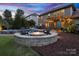 Backyard features a stone fire pit with chairs and a view of the outdoor living space at 1026 Arges River Dr, Fort Mill, SC 29715