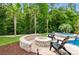 Outdoor fire pit with stone surround, lounge chairs, and well-manicured landscaping and spa at 1026 Arges River Dr, Fort Mill, SC 29715