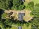 An aerial view showing the well maintained roof and surrounding wooded neighborhood at 108 Woodwinds St, Locust, NC 28097