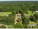 An aerial view displays the home's location surrounded by mature trees and some neighborhood amenities at 108 Woodwinds St, Locust, NC 28097
