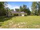 Wide shot of the backyard featuring a large, well-maintained lawn and the rear of the house at 108 Woodwinds St, Locust, NC 28097