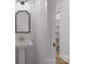 Bright powder room featuring stylish pedestal sink and decorative mirror at 108 Woodwinds St, Locust, NC 28097