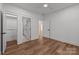 Bright bedroom with wood-look floors, ceiling fan, and doorways to closet, bathroom, and hall at 108 Woodwinds St, Locust, NC 28097