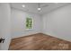 Bright bedroom features wood-look floors, white trim, ceiling fan, and a window overlooking the lawn at 108 Woodwinds St, Locust, NC 28097