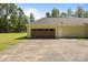 Spacious driveway leading to an attached garage with a dark wood door at 108 Woodwinds St, Locust, NC 28097